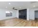 Contemporary living room with sleek entertainment center, modern fireplace, and wood flooring at 4385 Bramblewood St, Las Vegas, NV 89147