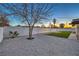 Large backyard with turf, rock, perimeter block fence, and mature tree at dusk at 4667 E Boston Ave, Las Vegas, NV 89104