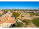 Aerial view of a desert home with lush landscaping, a tiled roof, and a desert golf course at 4796 Riva De Romanza St, Las Vegas, NV 89135