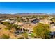 Expansive aerial view of a desert home with lush landscaping, a tiled roof, and mountain views at 4796 Riva De Romanza St, Las Vegas, NV 89135
