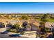 Beautiful aerial view of single-story home featuring well-manicured lawns, desert landscaping and a three car garage at 4796 Riva De Romanza St, Las Vegas, NV 89135