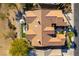 Birds eye aerial view of a desert home with a terracotta roof, lush landscaping, and an umbrella covered patio at 4796 Riva De Romanza St, Las Vegas, NV 89135