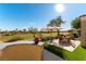 Backyard view of a patio with seating, an umbrella, and a lush golf course beyond at 4796 Riva De Romanza St, Las Vegas, NV 89135