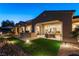 Exterior view of the backyard at dusk, featuring a patio, outdoor kitchen, and desert landscaping at 4796 Riva De Romanza St, Las Vegas, NV 89135