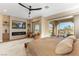Luxurious main bedroom featuring a modern fireplace, flat-screen TV, and access to an outdoor patio at 4796 Riva De Romanza St, Las Vegas, NV 89135