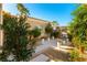 Well-manicured courtyard with decorative stone features, potted flowers, and desert landscaping at 4796 Riva De Romanza St, Las Vegas, NV 89135