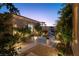 Charming courtyard with stone accents, potted plants, trees, and manicured landscaping at 4796 Riva De Romanza St, Las Vegas, NV 89135