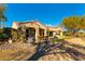 Desert home with a covered patio, outdoor kitchen, and lush landscaping at 4796 Riva De Romanza St, Las Vegas, NV 89135
