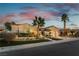 Charming single-story home showcasing desert landscaping and palm trees against a picturesque twilight sky at 4796 Riva De Romanza St, Las Vegas, NV 89135
