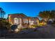 Exterior view of the home at night featuring a covered patio, outdoor kitchen, and landscape lighting at 4796 Riva De Romanza St, Las Vegas, NV 89135