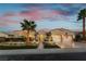 Charming single story home with desert landscaping, tall palm trees, and a paved walkway to the front door at 4796 Riva De Romanza St, Las Vegas, NV 89135
