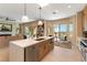 Open-concept kitchen with a central island, modern appliances, and adjacent breakfast nook and living area at 4796 Riva De Romanza St, Las Vegas, NV 89135