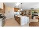 Modern kitchen flowing into the living room, with stainless steel appliances, a large island, and barstool seating at 4796 Riva De Romanza St, Las Vegas, NV 89135
