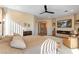Bright main bedroom with wood floors, ceiling fan, and fireplace with a flatscreen TV at 4796 Riva De Romanza St, Las Vegas, NV 89135