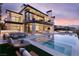 Twilight view of a modern home with a pool, patio, and outdoor dining at 4918 Summit Overlook Dr, Las Vegas, NV 89135