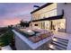 A modern home featuring outdoor entertainment space, a fire pit, and ample seating for gatherings at 4918 Summit Overlook Dr, Las Vegas, NV 89135