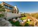 Manicured backyard featuring a stone wall, outdoor seating, and lush landscaping at 4918 Summit Overlook Dr, Las Vegas, NV 89135