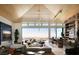 Expansive living room with vaulted ceilings, stone bar, and floor-to-ceiling windows showcasing panoramic views at 4918 Summit Overlook Dr, Las Vegas, NV 89135
