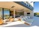 Covered outdoor patio with daybeds, lounge chairs, and a dining area at 4918 Summit Overlook Dr, Las Vegas, NV 89135