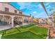 Large backyard features a covered patio with furniture and artificial turf at 4938 Via Luis Ct, North Las Vegas, NV 89031