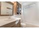 Bright bathroom featuring a shower and tub combo, modern fixtures, and wood cabinetry at 4938 Via Luis Ct, North Las Vegas, NV 89031