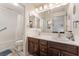 Bathroom featuring dual sinks with dark wood cabinetry, and a shower and tub combo at 4938 Via Luis Ct, North Las Vegas, NV 89031