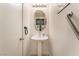 Chic half bathroom features an oval mirror and pedestal sink at 4938 Via Luis Ct, North Las Vegas, NV 89031