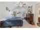 Cozy bedroom with a ceiling fan, neutral carpet, bright windows, and ensuite bathroom at 4938 Via Luis Ct, North Las Vegas, NV 89031
