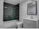 Modern bathroom features a tub with sleek tiling, new vanity, and stylish mirror at 501 National St, Henderson, NV 89015