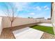 Fenced backyard with concrete patio, rock landscaping, and a patch of synthetic grass at 5648 Alitak Bay St, North Las Vegas, NV 89081