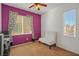 Bedroom featuring vibrant accent wall, neutral carpet, and a window with views of the surrounding neighborhood at 6121 Sinatra Sands Ct, Las Vegas, NV 89130
