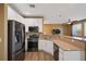 Modern kitchen with stainless steel appliances, stone countertops, white cabinets, and barstool seating at 6121 Sinatra Sands Ct, Las Vegas, NV 89130