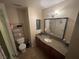 Bathroom featuring vanity with granite counters, decorative mirror, sink and open shelving for storage at 7200 Pirates Cove Rd # 1025, Las Vegas, NV 89145
