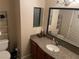 Bright bathroom featuring vanity with granite counters, decorative mirror, sink and open shelving for storage at 7200 Pirates Cove Rd # 1025, Las Vegas, NV 89145