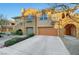 Two-story townhouse features attached garage, desert landscaping, and decorative architectural details at 820 Canterra St # 1054, Las Vegas, NV 89138