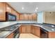 Cozy kitchen featuring wooden cabinetry, granite countertops and modern appliances at 820 Canterra St # 1054, Las Vegas, NV 89138