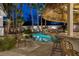 Beautifully landscaped backyard with a custom pool, waterfall feature, and covered outdoor seating area at 8211 Windsor Crest Ct, Las Vegas, NV 89123