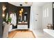 Modern bathroom featuring double sinks, wood accents, stylish light fixtures, and a luxurious bathtub at 8211 Windsor Crest Ct, Las Vegas, NV 89123