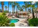 Inviting poolside bar with a thatched roof, seating, and serene views of the pool and lush landscaping at 8211 Windsor Crest Ct, Las Vegas, NV 89123