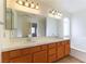 Bathroom with double sinks, white counters, bath tub, and wood cabinets at 8217 Maplestar Rd, Las Vegas, NV 89128