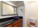 Powder room featuring a vessel sink, dark granite countertop and wood vanity at 8217 Maplestar Rd, Las Vegas, NV 89128