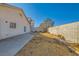 Expansive backyard featuring a concrete patio, block wall, and ample space for outdoor activities at 8728 Honey Vine Ave, Las Vegas, NV 89143