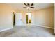 Bedroom featuring neutral carpet, ceiling fan, and an en-suite bathroom at 8728 Honey Vine Ave, Las Vegas, NV 89143