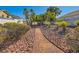 Community walking path lined with trees, bushes and decorative rocks at 8728 Honey Vine Ave, Las Vegas, NV 89143