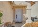 Beige home with stucco and a white front door and pillars at 8728 Honey Vine Ave, Las Vegas, NV 89143
