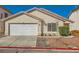 Single story home with neutral stucco, tile roof, rock landscaping, and a two car garage at 8728 Honey Vine Ave, Las Vegas, NV 89143