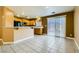 Open kitchen design with wooden cabinets, black appliances, and a breakfast bar connecting to a spacious living area at 8728 Honey Vine Ave, Las Vegas, NV 89143