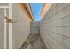 Narrow side yard area featuring block walls, gravel, and a metal gate for access at 8728 Honey Vine Ave, Las Vegas, NV 89143