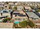 An aerial view features a backyard with a refreshing pool and solar panels in a well-maintained neighborhood setting at 10417 Artful Stone Ave, Las Vegas, NV 89149