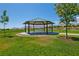 Scenic gazebo features seating, a shaded roof, and is surrounded by well-maintained grass at 10417 Artful Stone Ave, Las Vegas, NV 89149